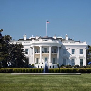 a large building with a grassy field with White House in the background